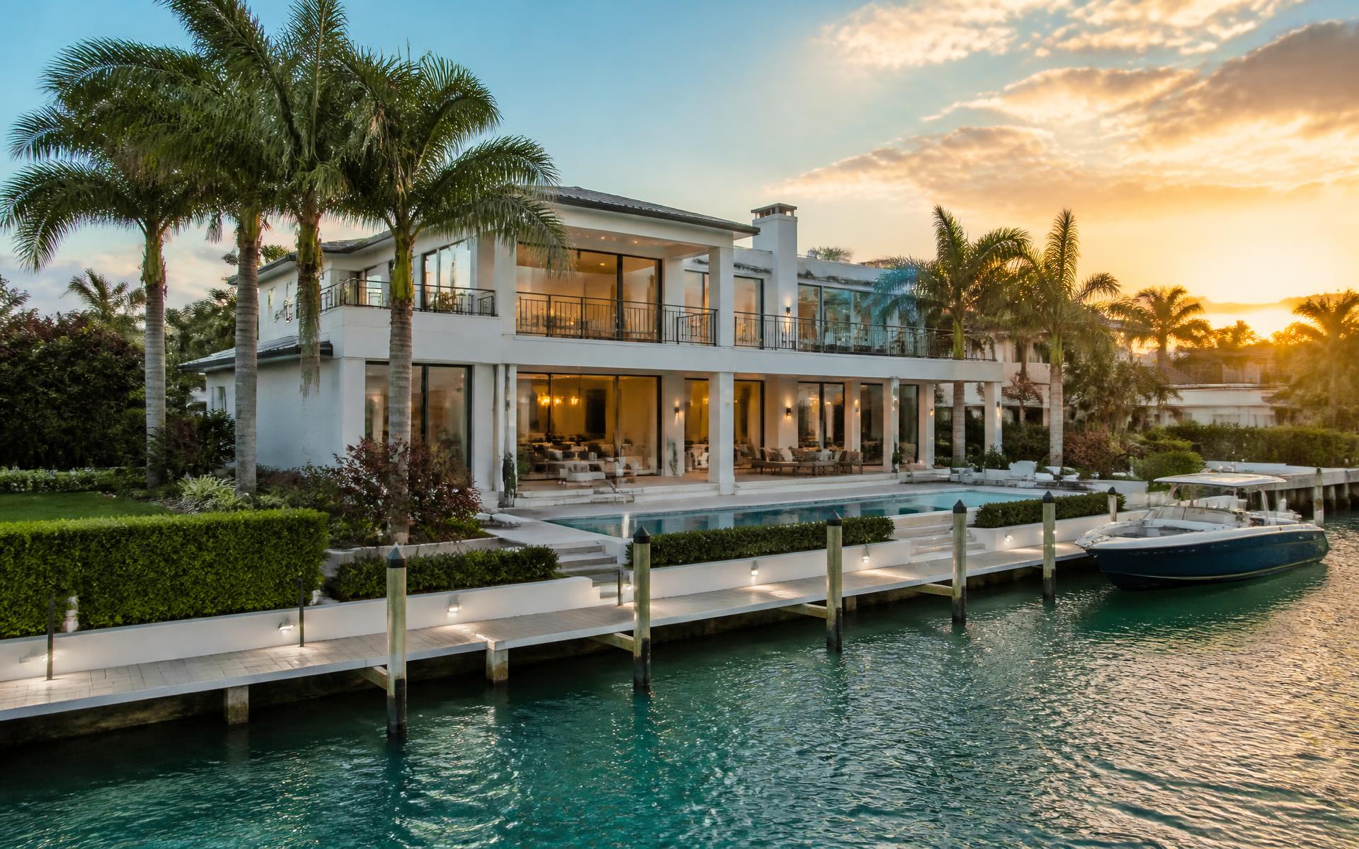 Waterfront South Florida home at sunset with palm trees and a private dock
